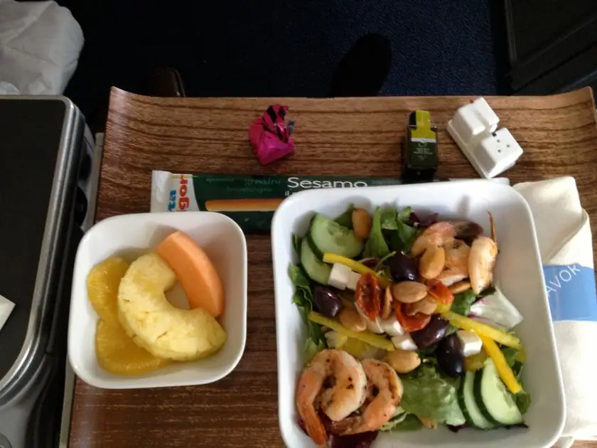 Garnelen-Gemüse-Salat mit Obst auf dem Tabletttisch in der Delta Business Class