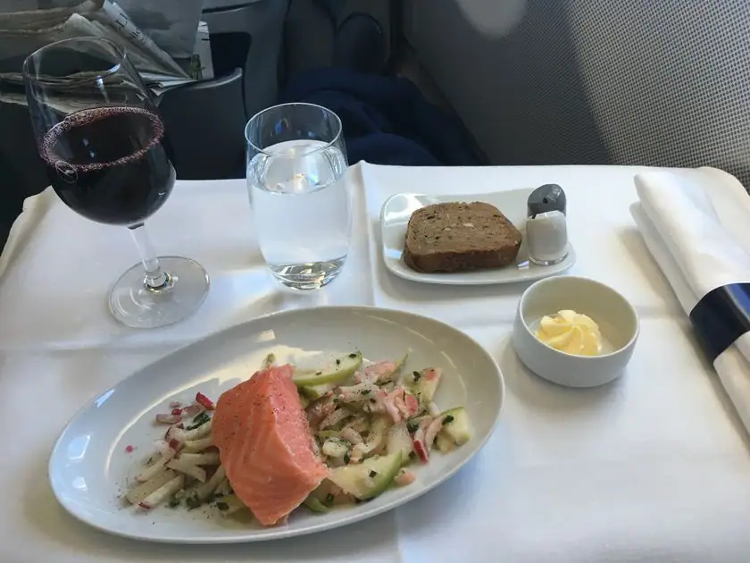 Vorspeise mit Lachs und Gurke, dazu Rotwein und Brot, in der Lufthansa Business Class