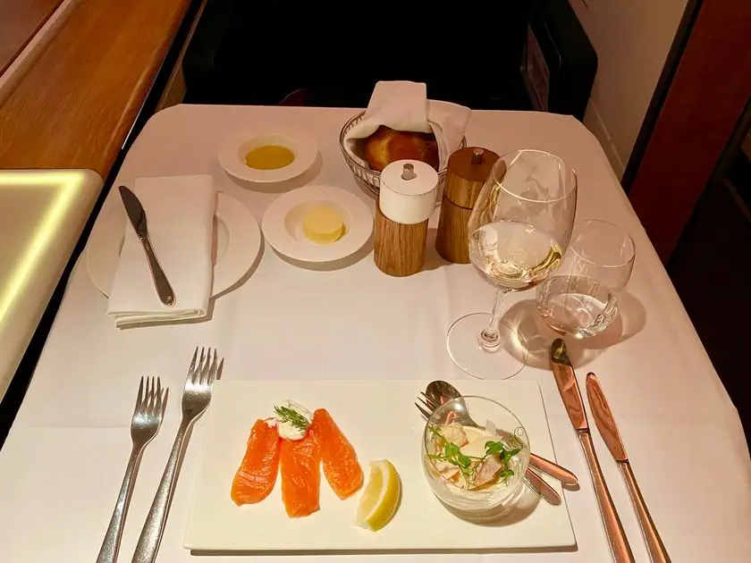 Gedeckter Tisch in der First Class mit Balik-Lachs, Kaviar, Weißwein und einer Rose