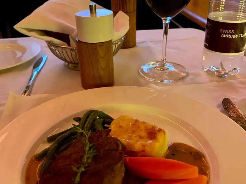 Steak mit Beilagen und ein Glas Rotwein in der Swiss First Class