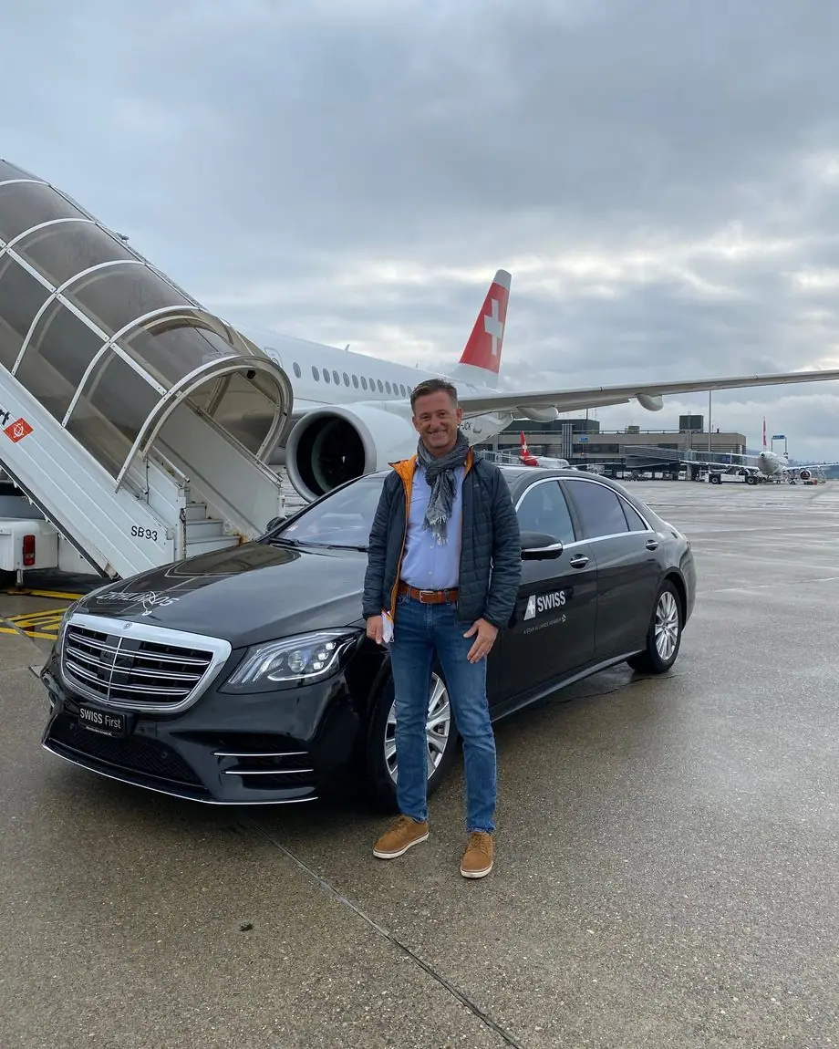 Eine schwarze Limousine steht auf dem Vorfeld neben einem Flugzeug der SWISS