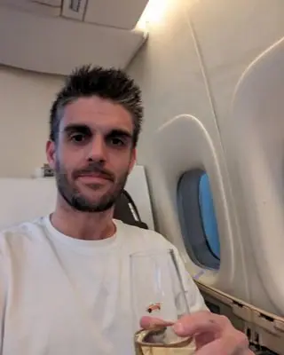 Paul J. mit einem Glas Champagner am Fensterplatz einer Premium-Kabine