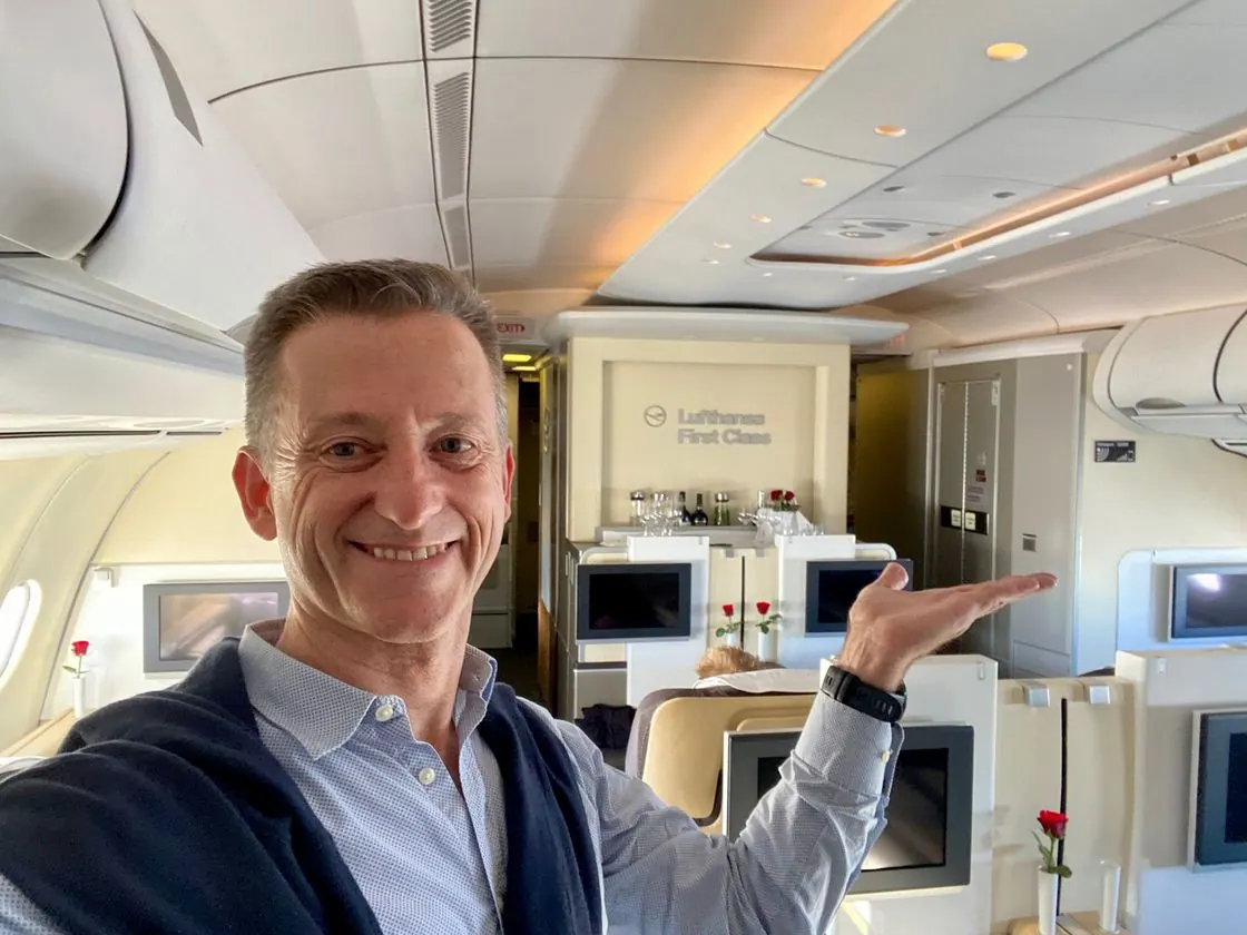 Oliver Gottstein steht mit ausgebreiteten Armen in der Kabine der Lufthansa First Class